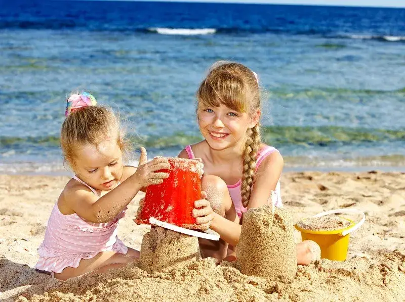 dzieci bawiące się na plaży lub w aquaparku nad morzem