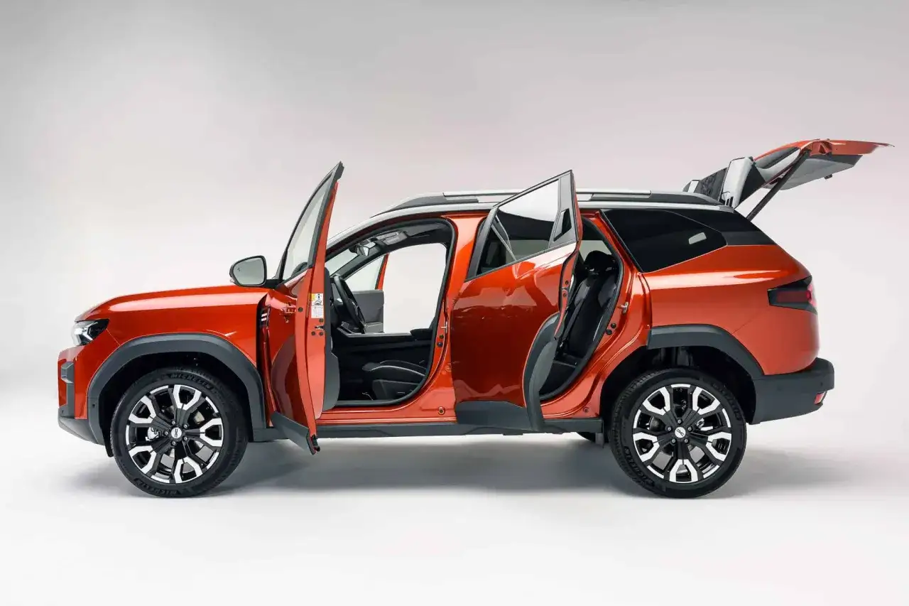 Pomarańczowy Dacia Bigster z otwartymi drzwiami i bagażnikiem. Czekamy na informacje o jego silnikach.