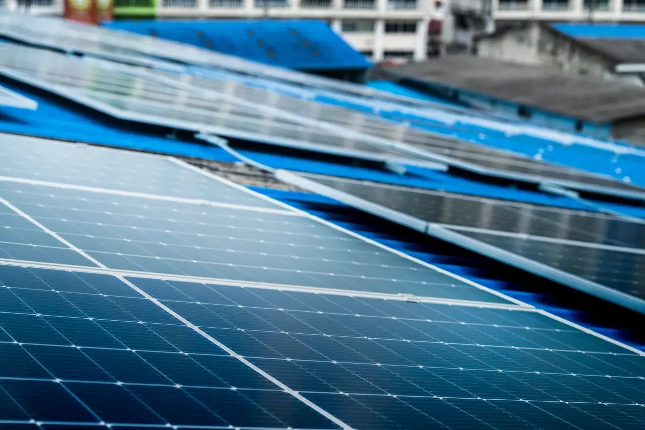 Panele fotowoltaiczne na niebieskim dachu, symbolizujące długą żywotność i ekologiczną energię.