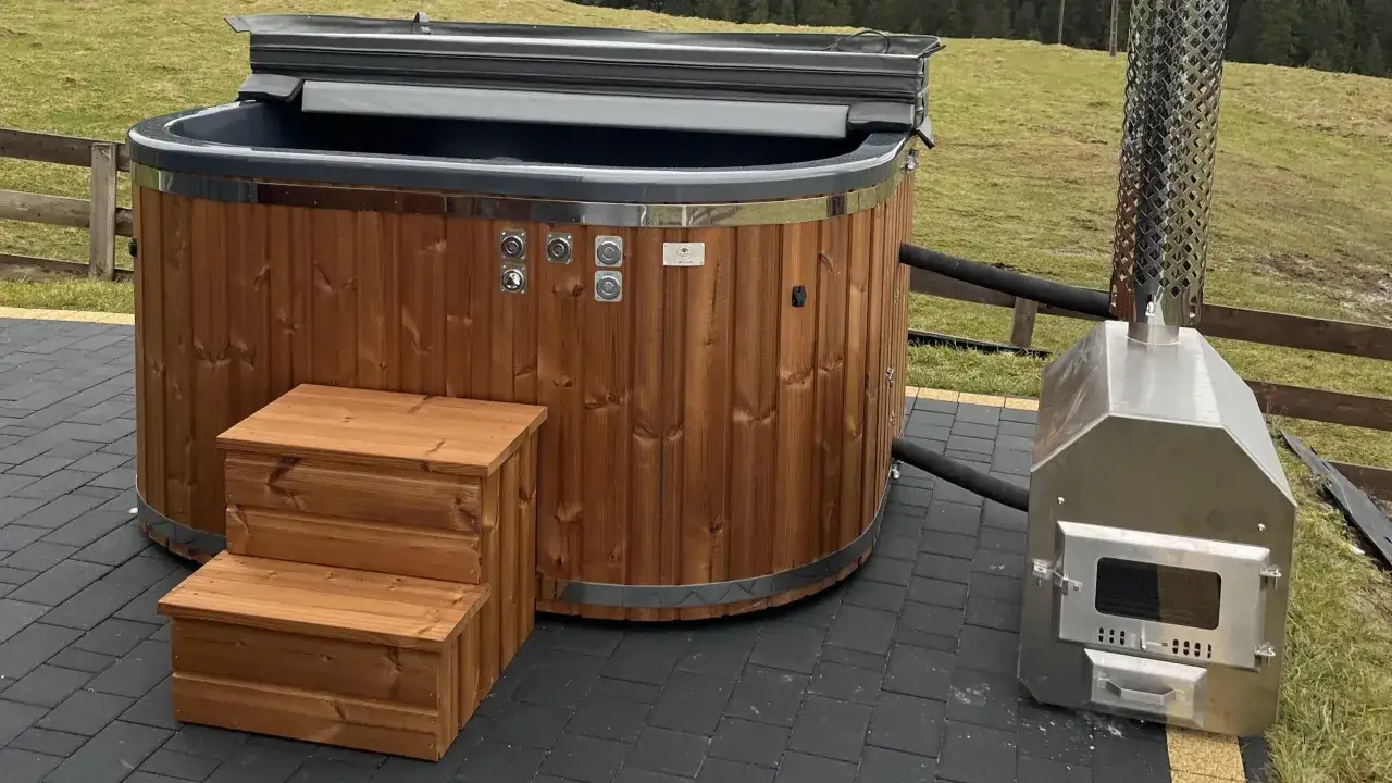 Drewniana balia ogrodowa z metalowym piecem, gotowa do budowy relaksu.