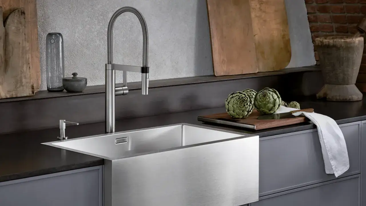 Nowoczesne zlewy do kuchni ze stali nierdzewnej, z elegancką baterią i artystycznymi dodatkami, tworzą stylową przestrzeń.