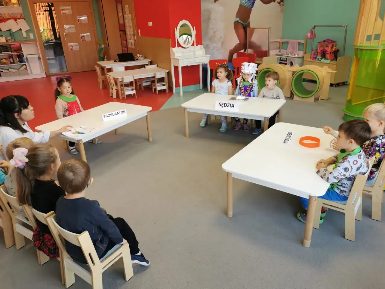 Dzieci w przedszkolu odgrywają role w sali sądowej. Zastanawiamy się, ile lat się chodzi do przedszkola, by tak sprawnie wcielać się w role prokuratora i sędziego.