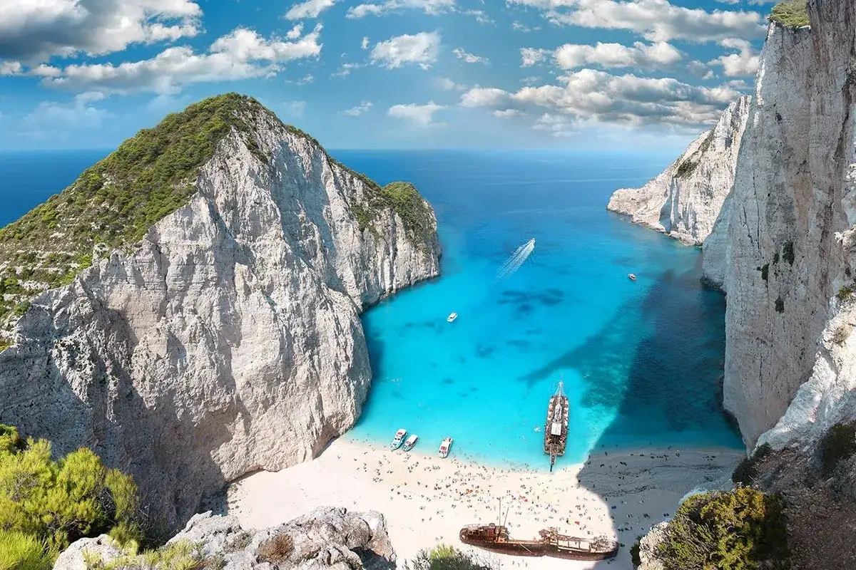Zatoka Navagio na Zakynthos, Grecja. Idealne miejsce, gdzie w Europie jest ciepło w listopadzie, z turkusową wodą i białym piaskiem.