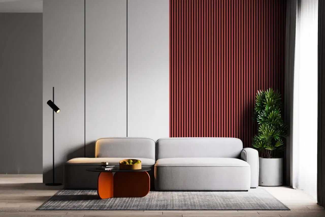 Nowoczesne wnętrza z szarą kanapą, pomarańczowym stolikiem i akcentem na ścianie.