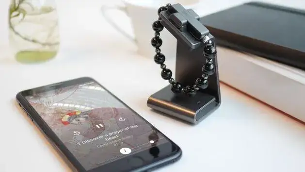 ekran smartfona z aplikacją religijną i otwartym laptopem z portalem katolickim