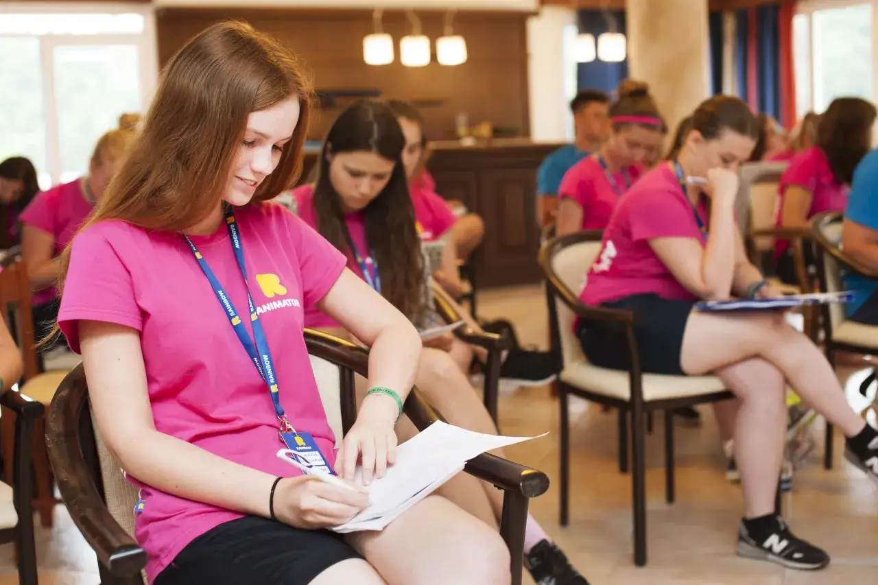 Młoda animatorka w różowej koszulce z napisem 