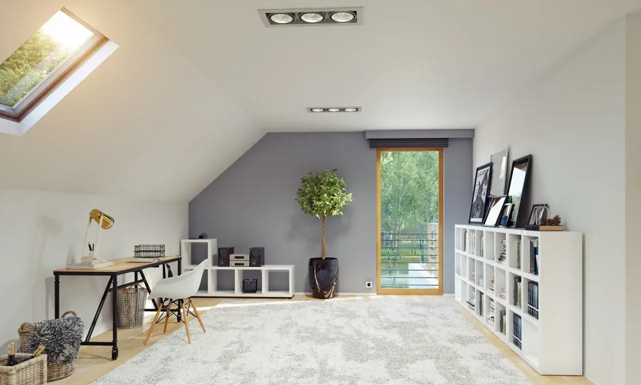 Jasne, nowoczesne poddasze z oknem dachowym i ledy na skosach. Biurko, regały, wygodny dywan i zieleń za oknem tworzą przytulną przestrzeń.