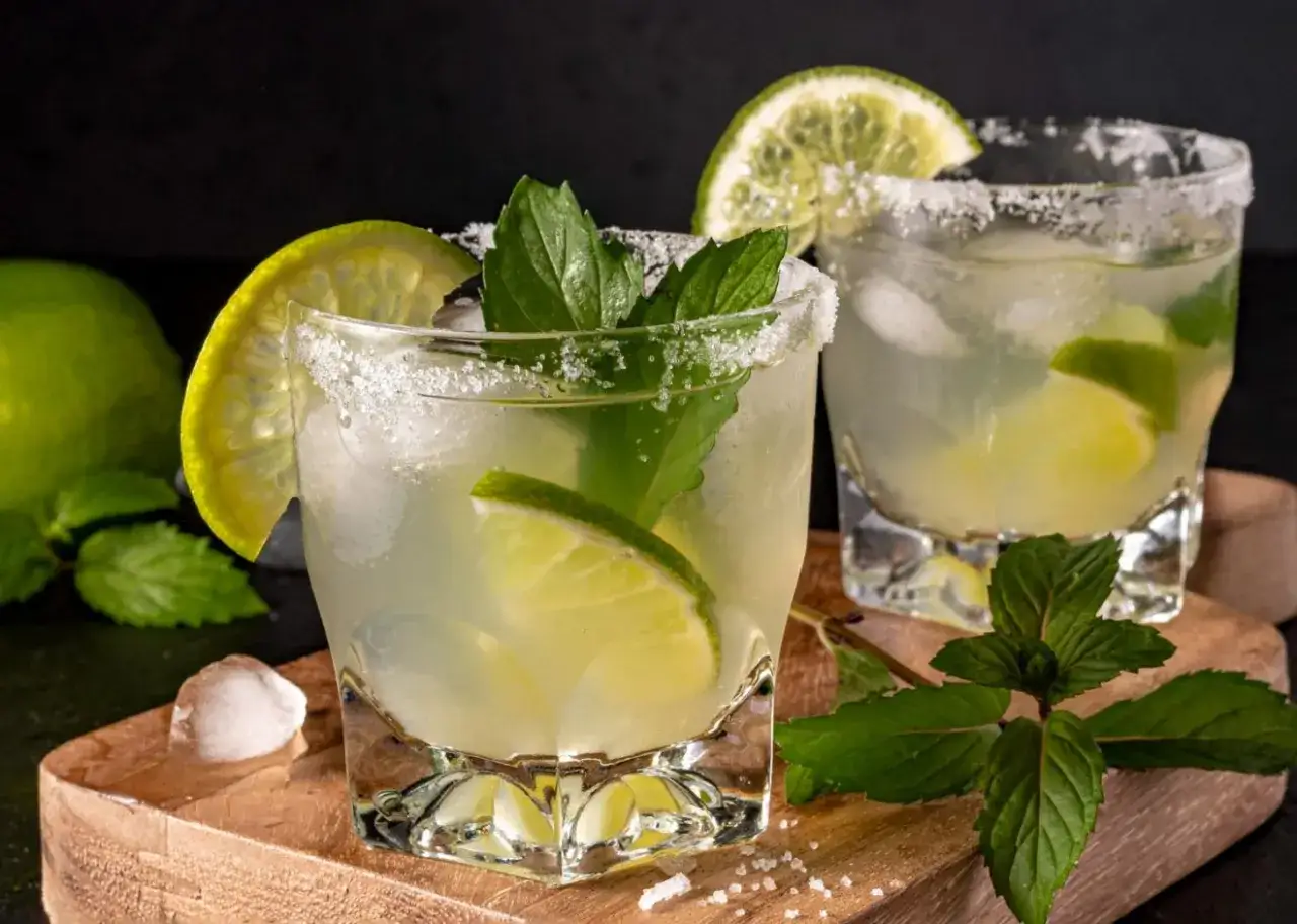 Orzeźwiający mohito drink składniki: lód, limonka, mięta i cukier na krawędzi szklanki.