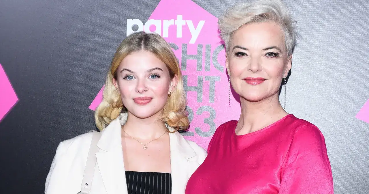 Dwie kobiety, matka i córka, pozują do zdjęcia. Córka, która poszła w ślady rodziców i zrobiła karierę, ma blond włosy i niebieskie oczy. Matka, z krótkimi siwymi włosami, uśmiecha się do aparatu.