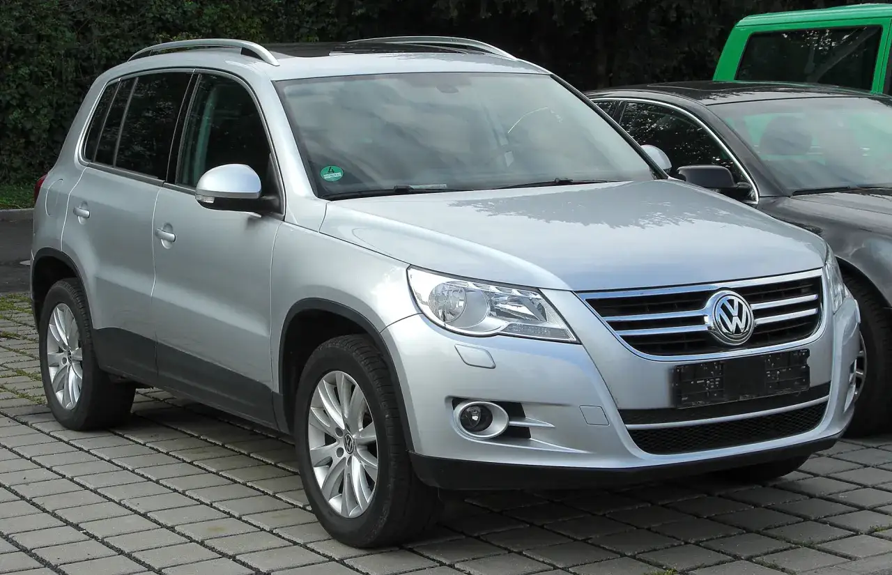 Srebrny VW Tiguan na kostce brukowej. Zastanawiasz się, jaki silnik wybrać do tego modelu?