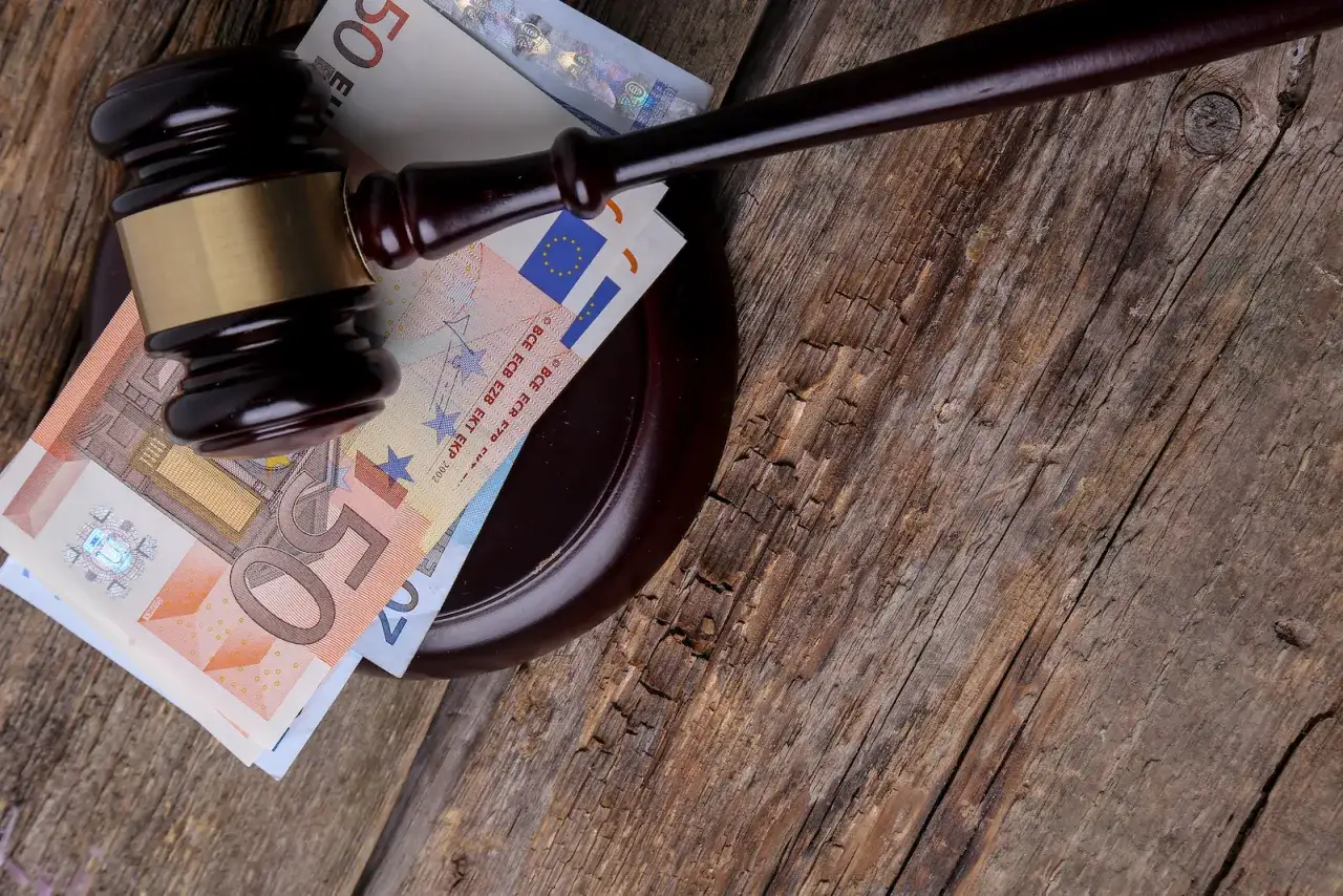 Młotek sędziowski na banknotach euro. Sytuacja, kiedy apelacja jest bezzasadna, może oznaczać straty finansowe.