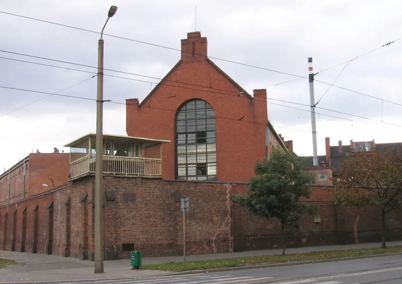 Budynek z cegły z wieżą strażniczą, przypominający architekturą to, co to znaczy penitencjarny.
