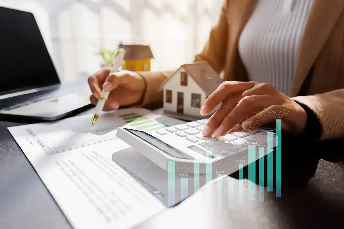 Osoba liczy koszty nieruchomości, analizując dane, by sprawdzić, czy podatek od nieruchomości jest w czynszu.