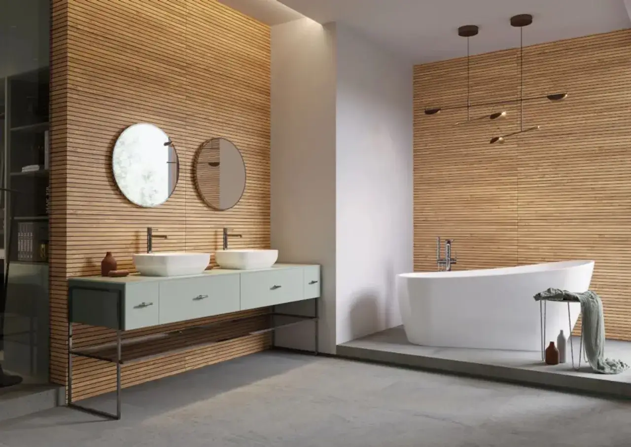 Nowoczesna łazienka z drewnianymi lamelami na ścianach, wolnostojącą wanną i podwójną umywalką.