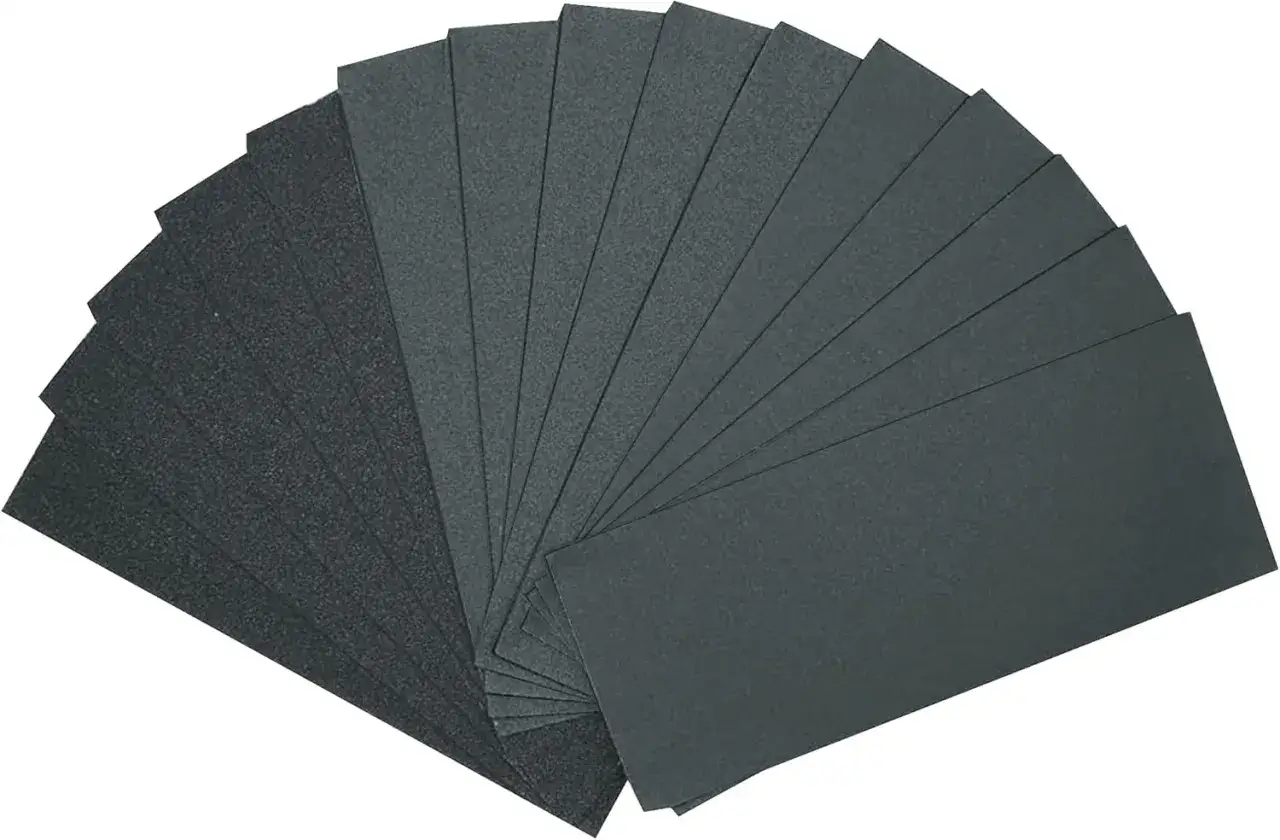 Zestaw arkuszy papieru ściernego do mebli, ułożonych wachlarzowo. Idealny do renowacji i wygładzania powierzchni.