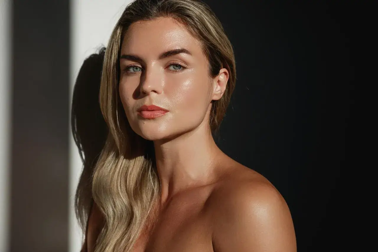 Kobieta z promienną cerą, podkreślającą, z czym nie łączyć witaminy C na twarz, by uniknąć podrażnień.