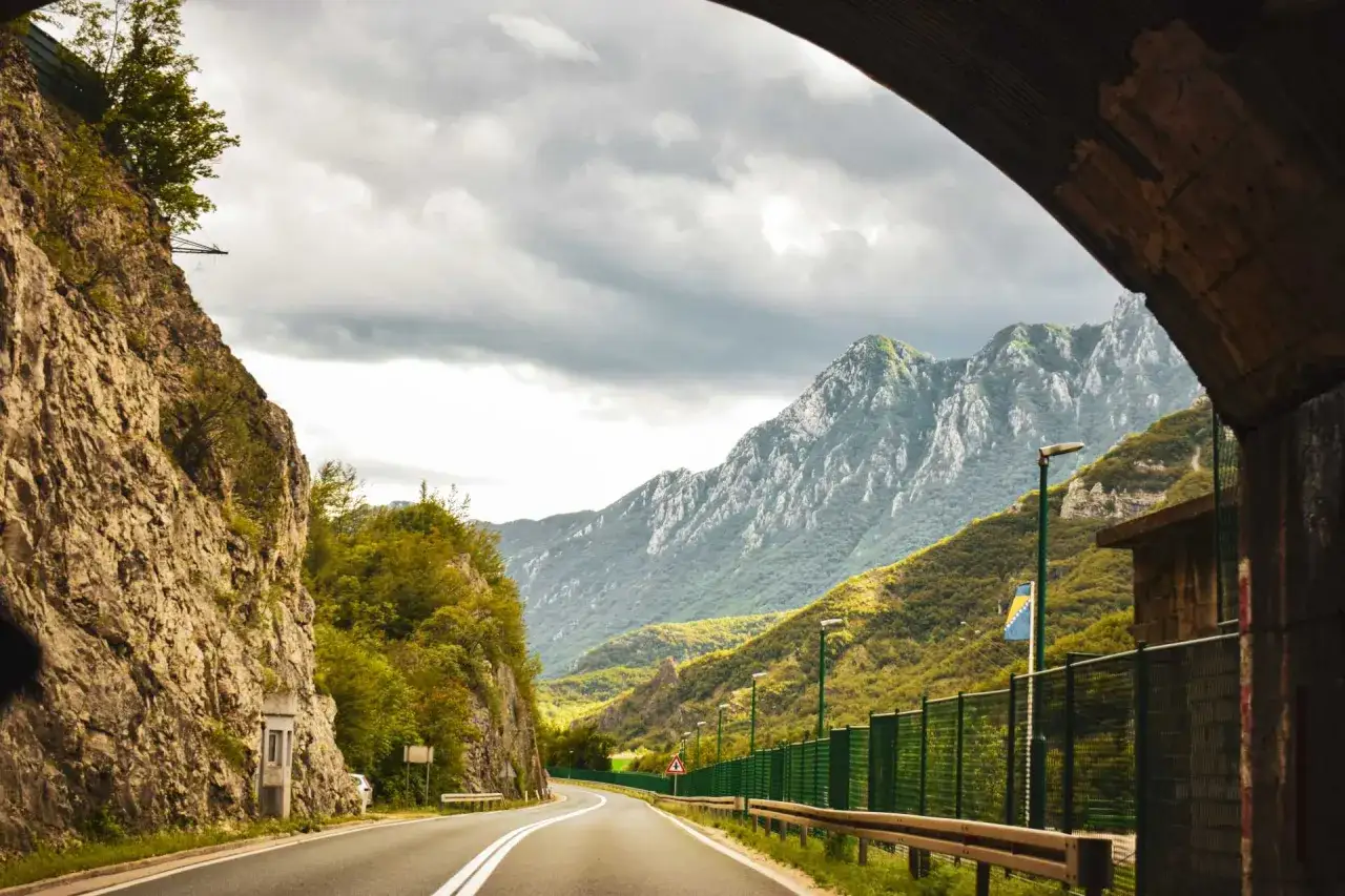 Droga przez góry, początek balkan trip. Skaliste zbocza, zielone wzgórza i potężne szczyty w oddali.
