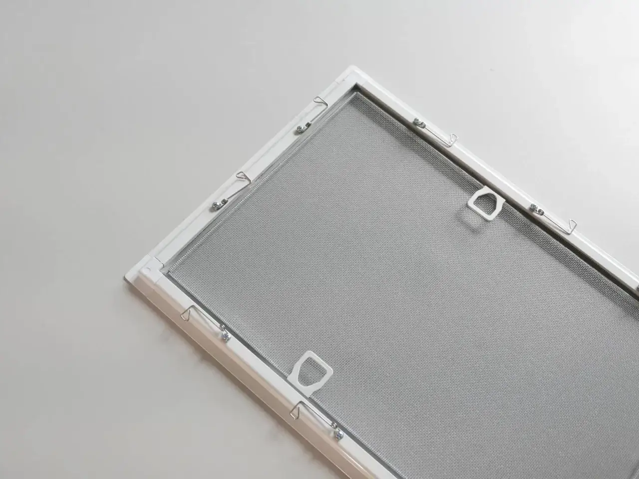 Biała roleta z moskitierą, gotowa do montażu, chroniąca przed owadami.