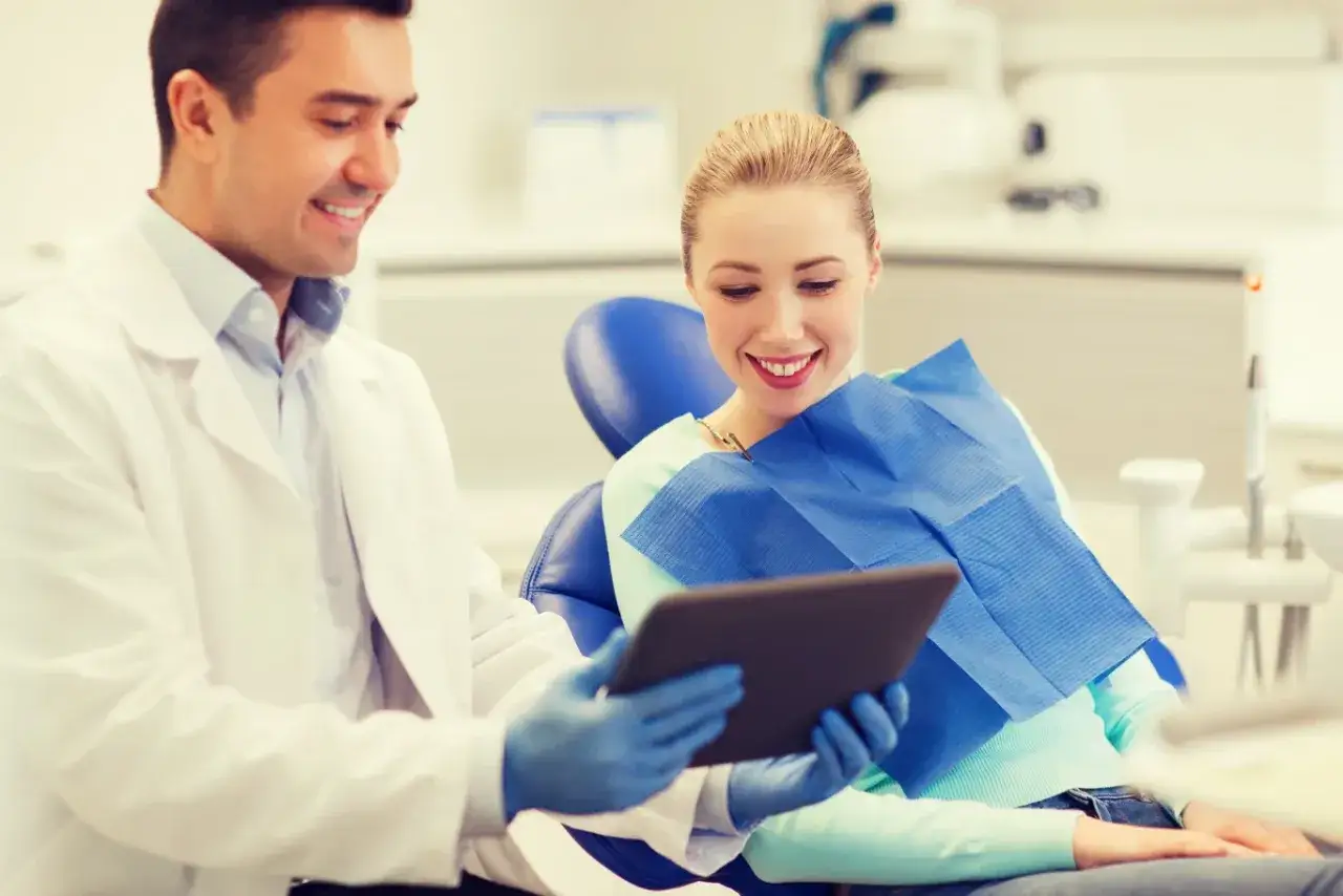 Dentysta omawia z pacjentką plan leczenia i odpowiada na pytanie: ile kosztuje wizyta u dentysty prywatnie.