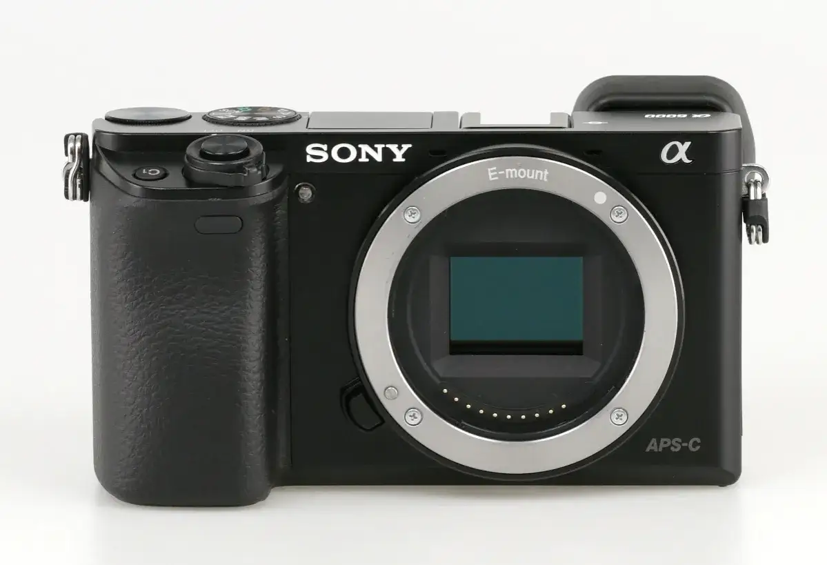 Czarny aparat Sony a6000, gotowy do test&oacute;w. Widoczny obiektyw E-mount i sensor APS-C.
