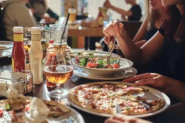 Osoba jedząca pizzę z sałatką