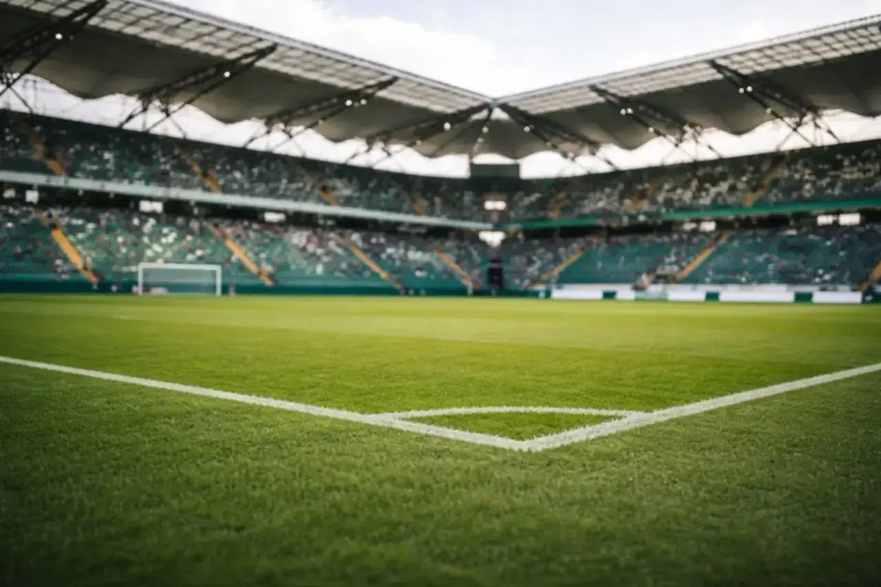 Pusta trybuna stadionu piłkarskiego, zielona murawa i bramka. Kibice czekają na wieści, ile drużyn awansuje do ekstraklasy.