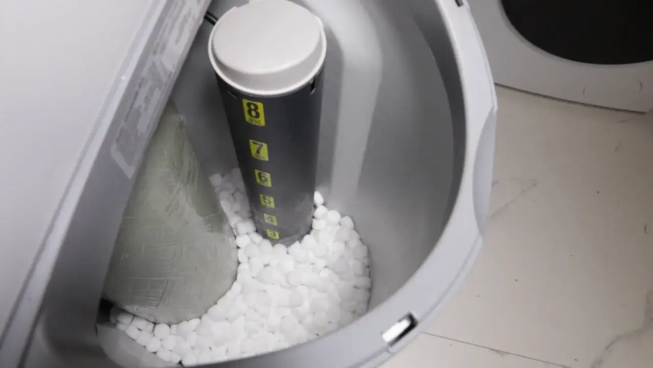 Wnętrze zmiękczacza wody z solą. Wskaźnik poziomu soli pokazuje 8. Dowiedz się, jak zamontować filtr do wody.