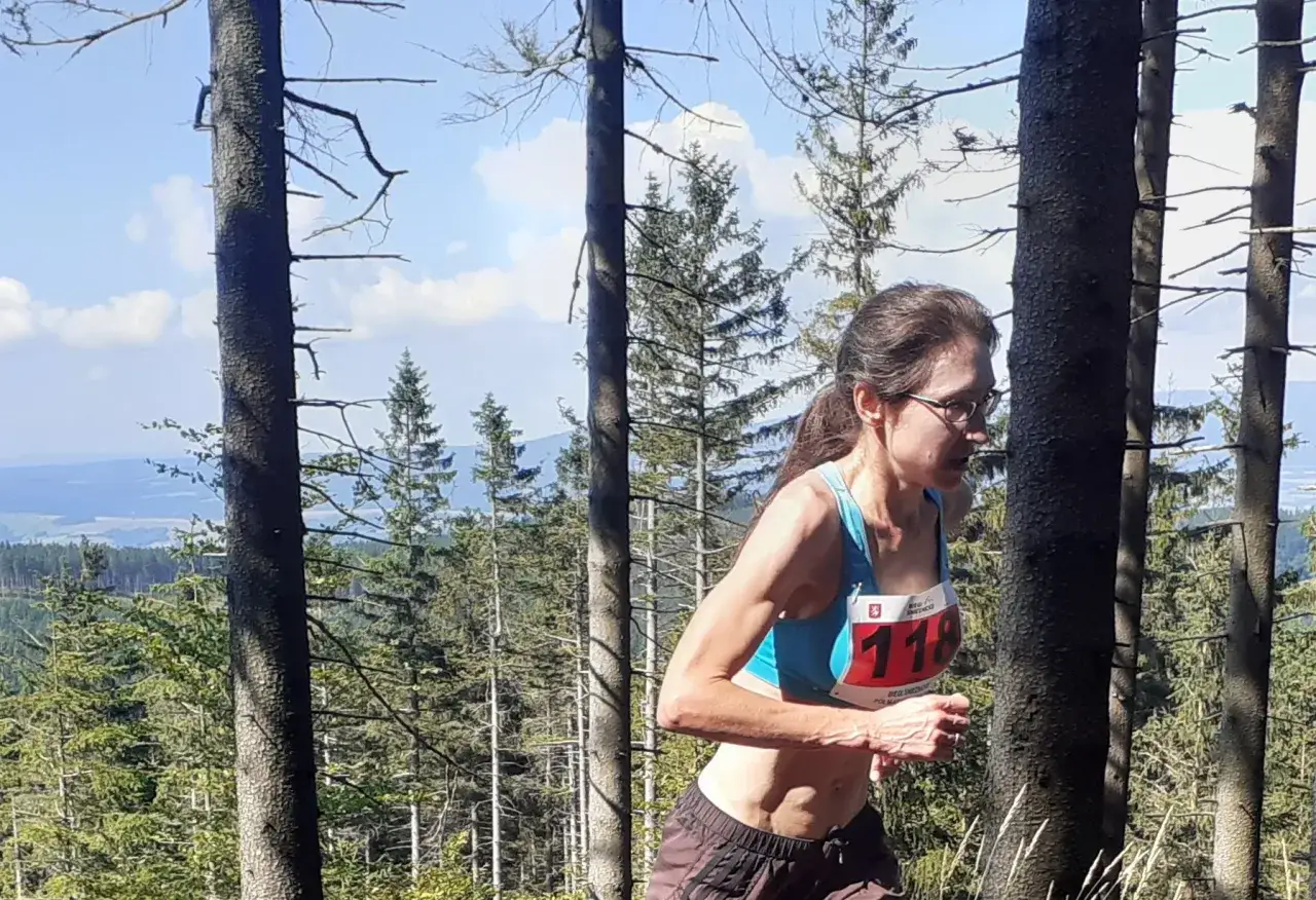 Anna Celińska biegnie przez las, numer startowy 118.