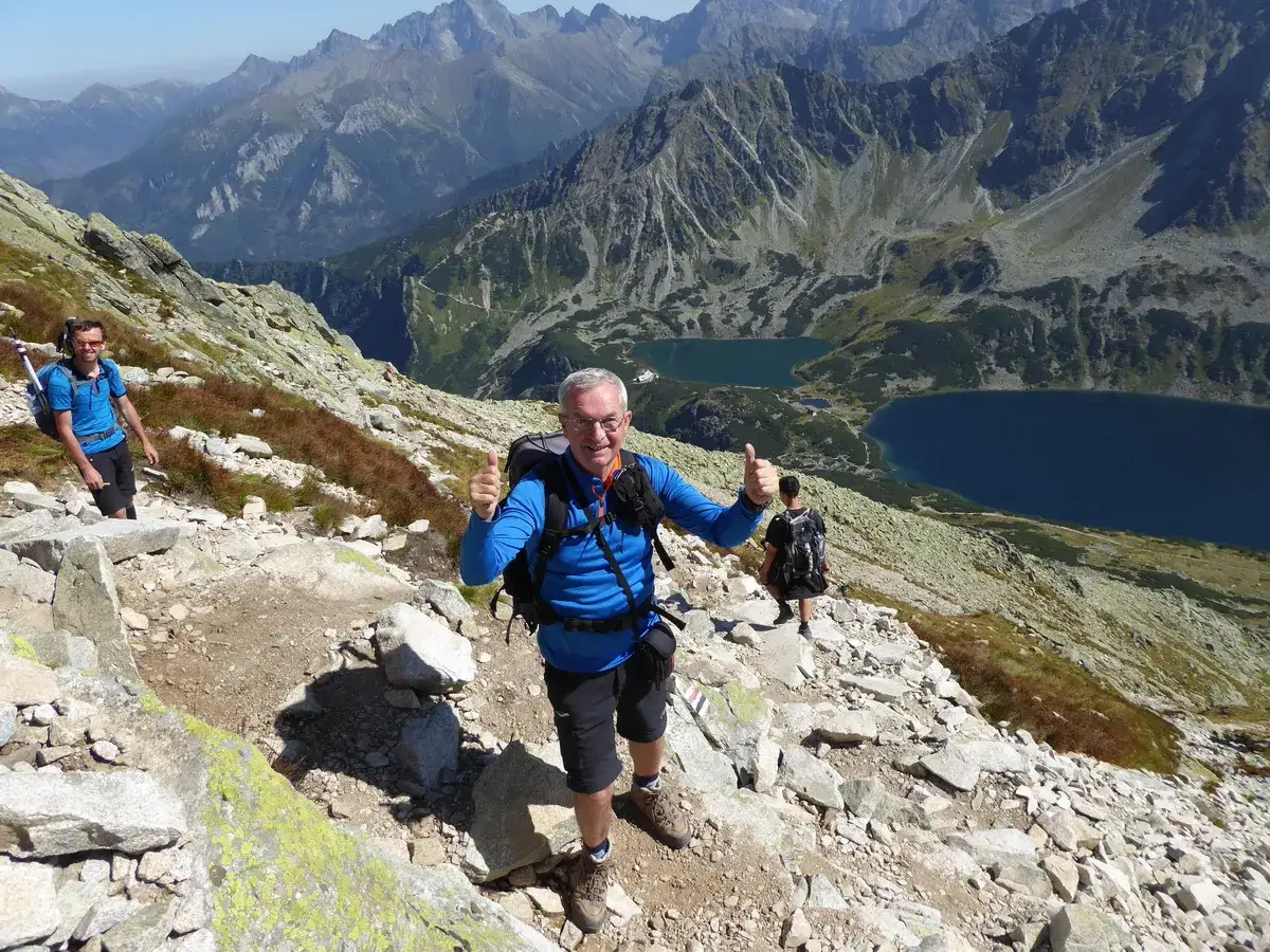 Trasa na Kozi Wierch: dwaj turyści z plecakami podziwiają widok na Tatry i Morskie Oko.