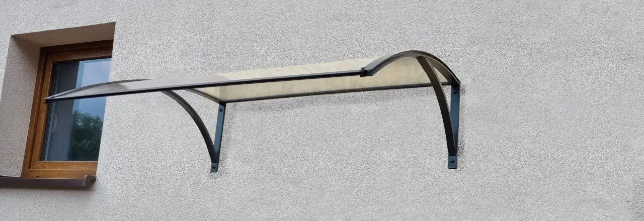 Różne rodzaje daszków nad drzwiami: drewniany, stalowy, z poliwęglanu, ze szkła