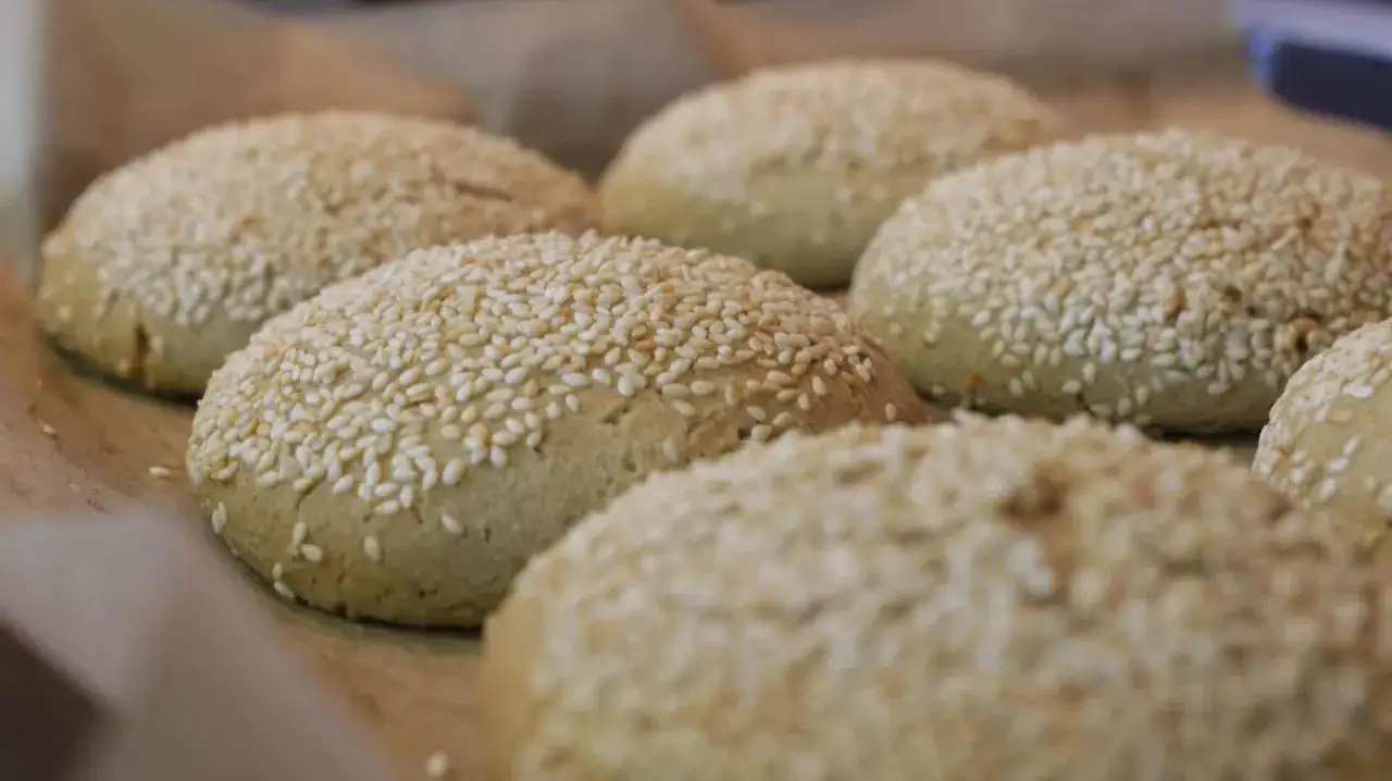 Świeżo upieczone bułki do burgerów bezglutenowe przepis. Posypane sezamem, gotowe do przygotowania pysznego burgera.
