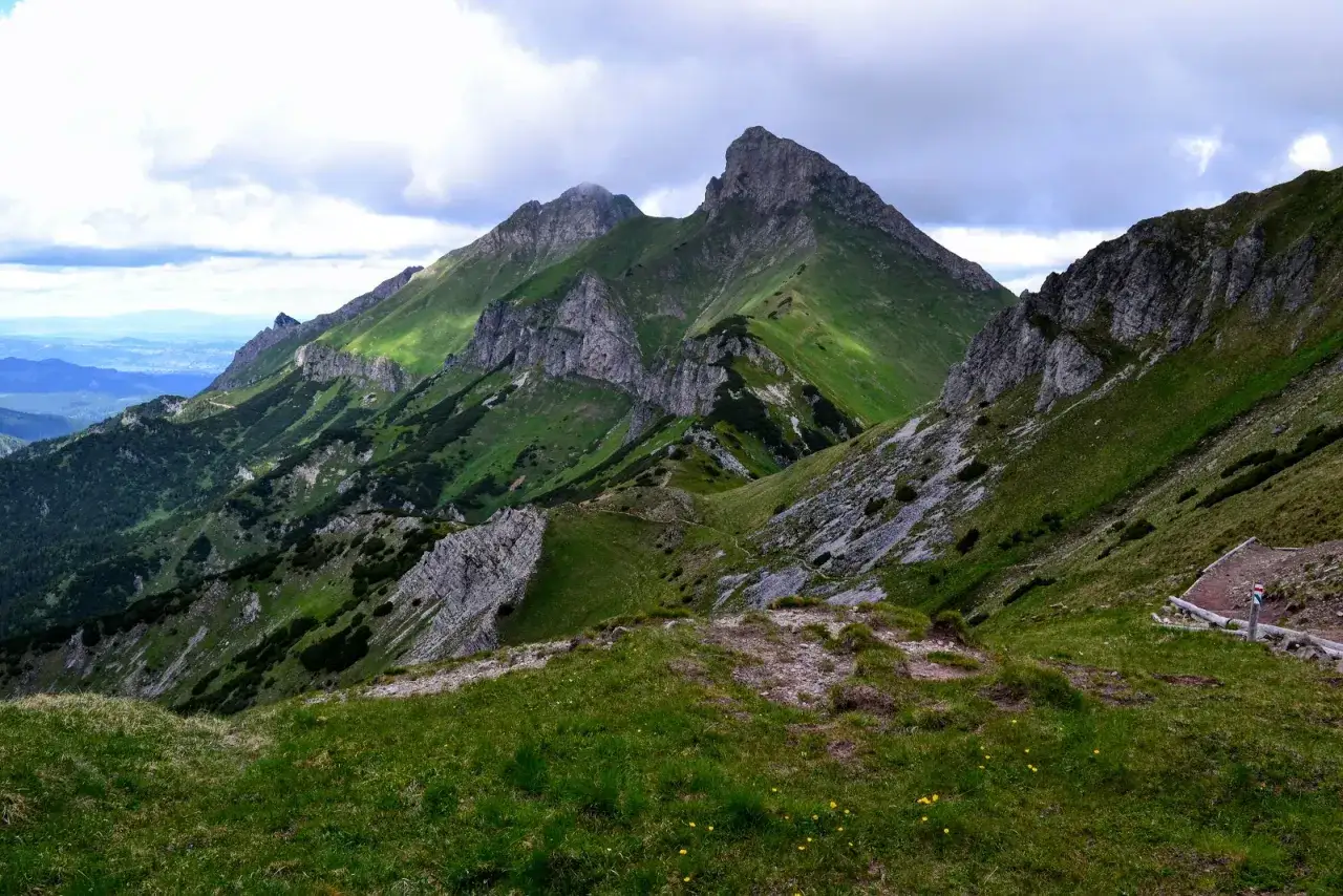 Zielona, skalista przełęcz w Tatrach z widokiem na ostre szczyty i chmury.