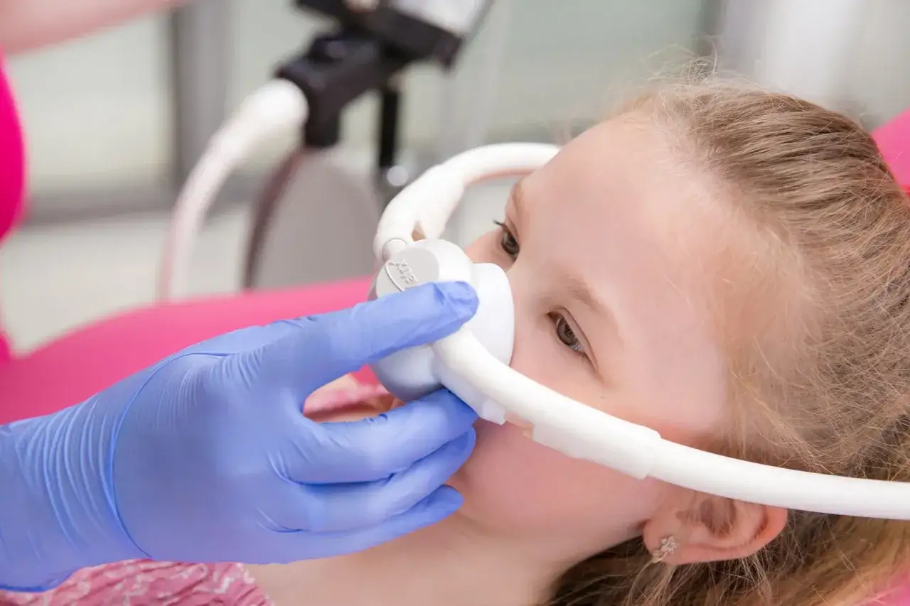 Dziecko z maseczką gazu rozweselającego u dentysty