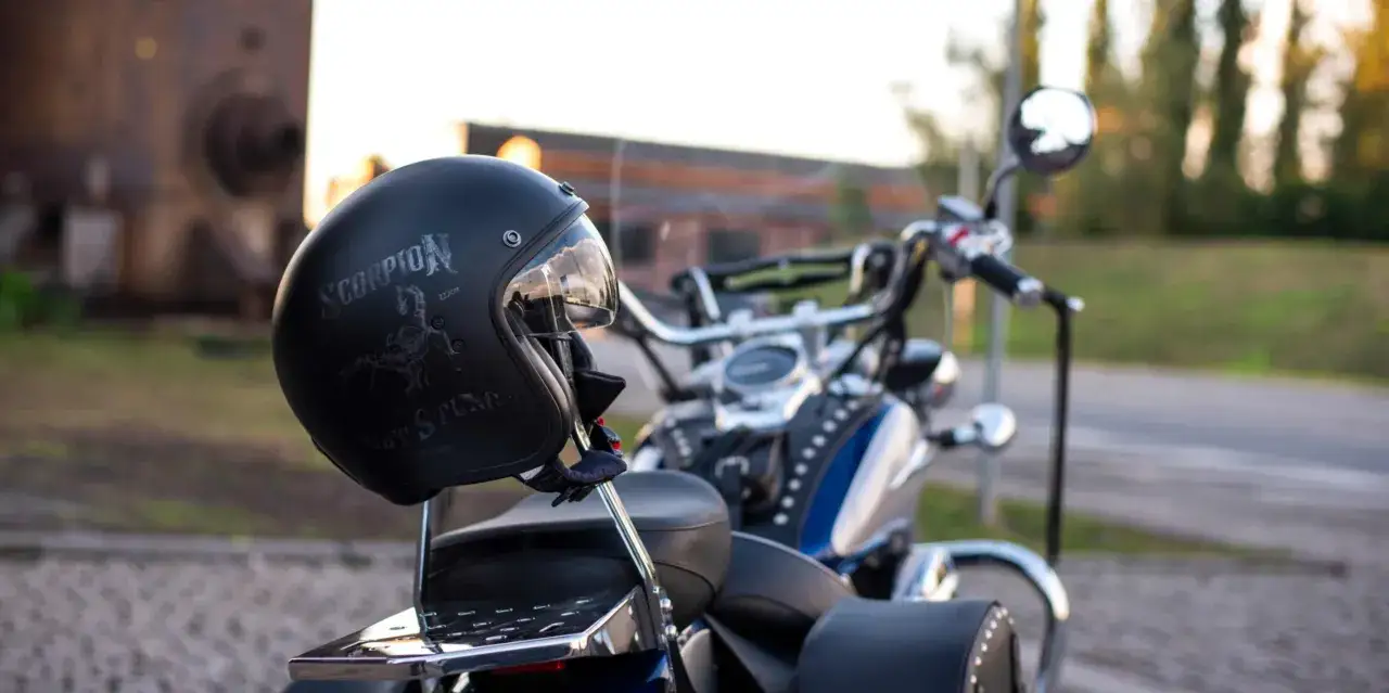 Czarny kask Scorpion z motywem skorpiona i motocykl. Niezbędne akcesoria dla motocyklisty gotowe do drogi.