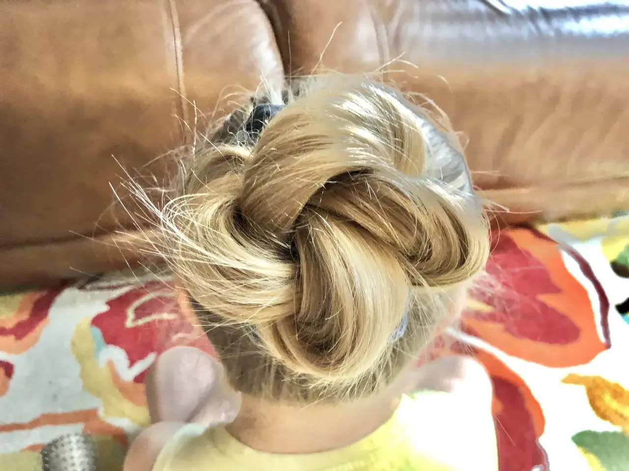 Niedbały messy bun z cienkich włosów, idealny na szybkie wyjście. Włosy lekko odstają, tworząc naturalny efekt.