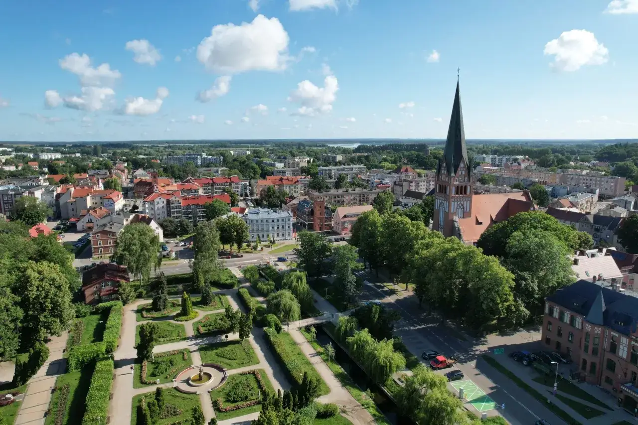 Widok z lotu ptaka na Szczecinek: zabytkowy kościół, park miejski z fontanną i urokliwe uliczki. Odkryj szczecinek atrakcje!