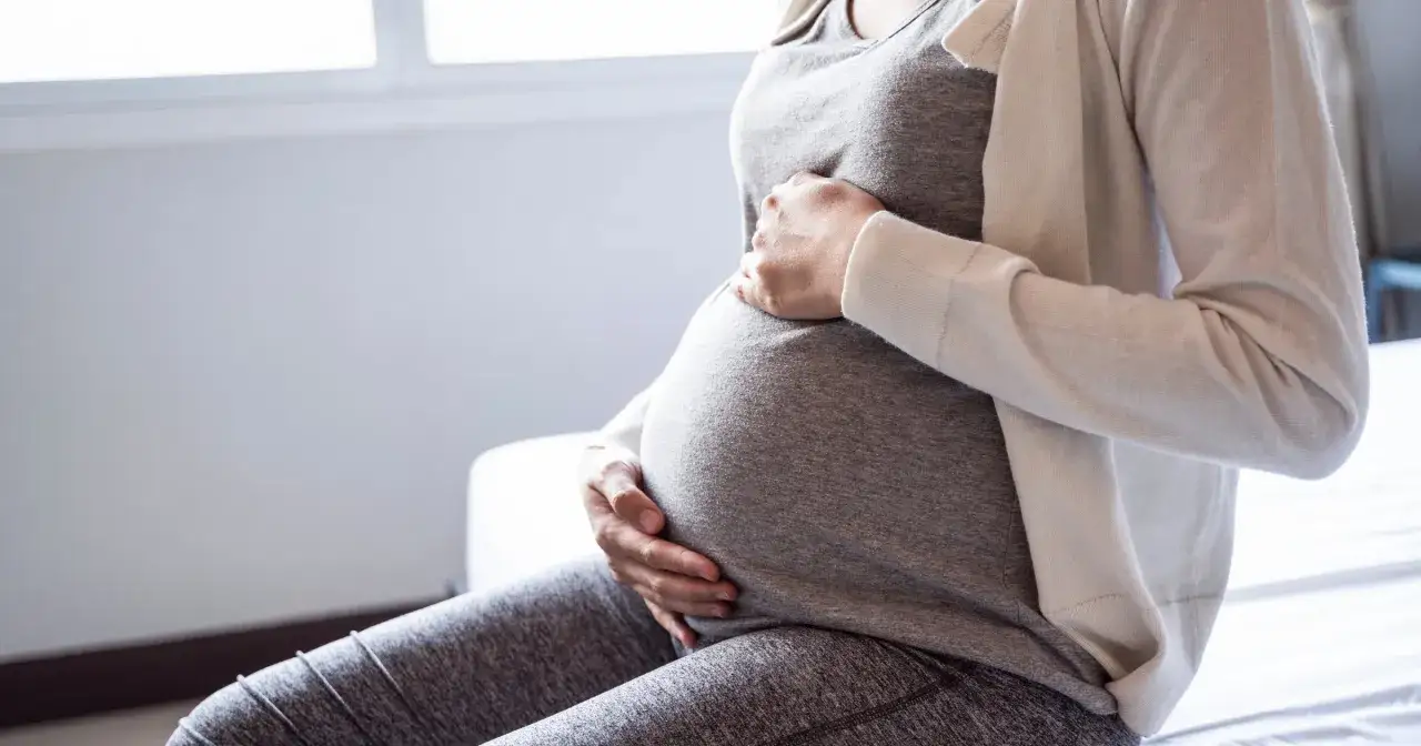 Ilustracja macicy z zagnieżdżającym się zarodkiem, delikatne światło, symbolika nowego życia