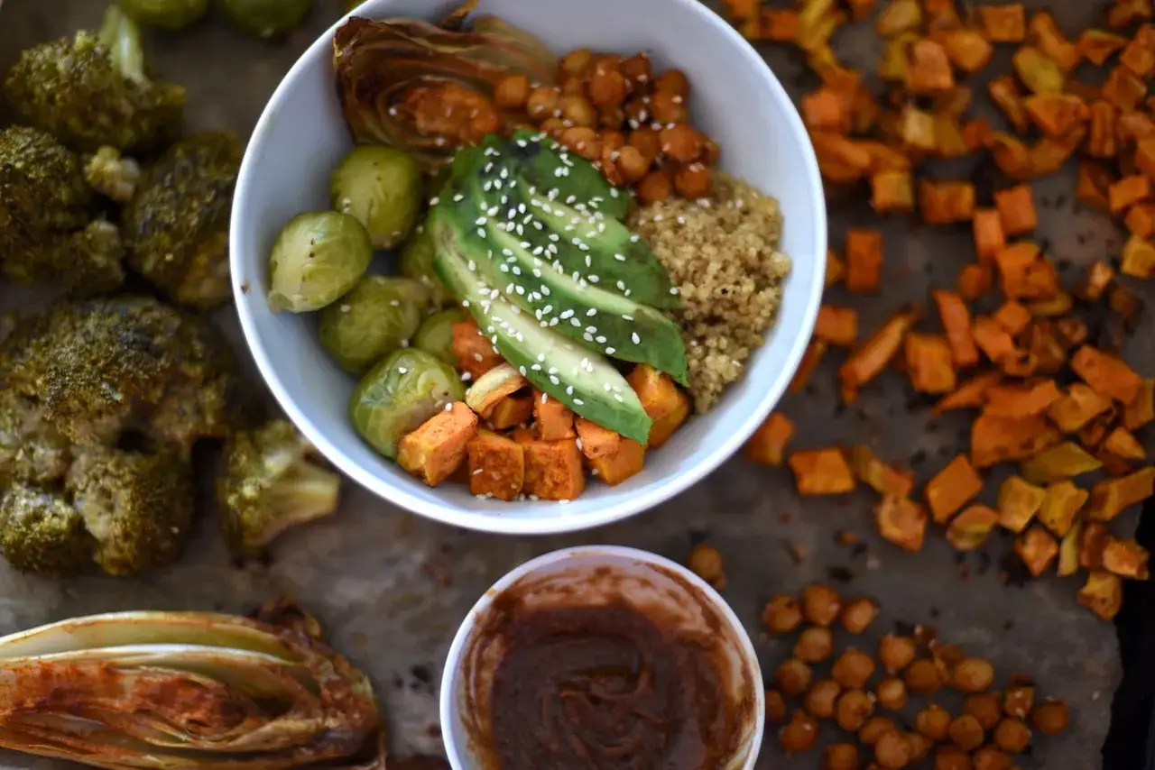 Zdrowa miska pełna warzyw, kaszy i awokado – tak jedzą buddyści. Pieczony brokuł, bataty, brukselka i ciecierzyca.