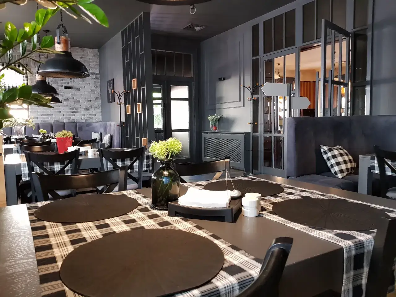Stylowe wnętrze restauracji, idealne miejsce, gdzie na lunch w Piotrkowie. Czekają stoliki z kratowanymi obrusami i wygodne fotele.