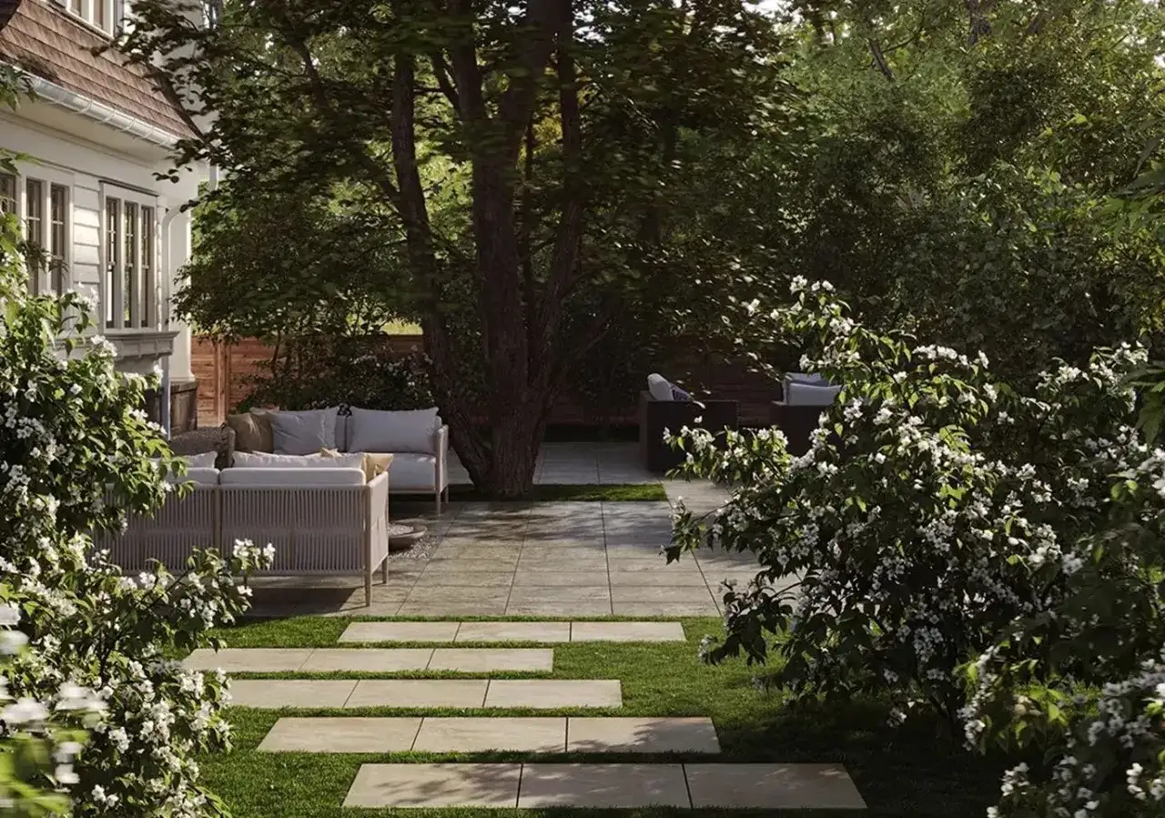 Nowoczesny ogr&oacute;d z wygodnymi meblami i ścieżką z płyt kamiennych. Idealne miejsce, by zacząć myśleć, jak zaplanować ogr&oacute;d.
