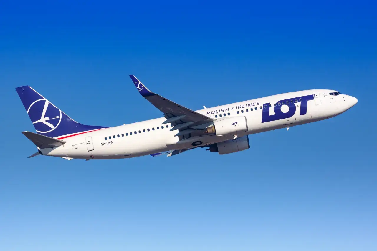 Samolot LOT Polish Airlines wznosi się na tle błękitnego nieba. Zastanawiasz się, ile trwa lot do Dubaju bez przesiadek?