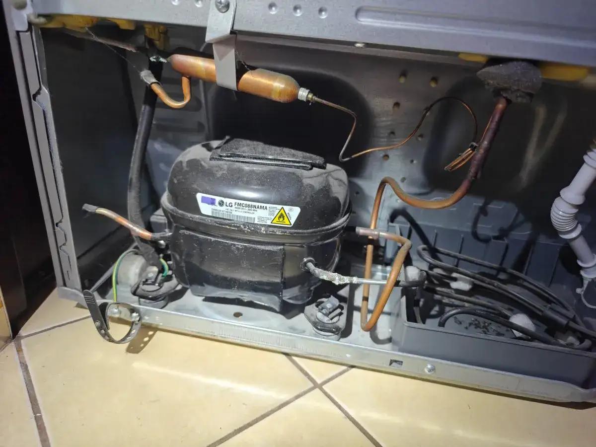 Widok wnętrza lod&oacute;wki z kompresorem LG. Rurki miedziane i przewody. Może to być przyczyna, dla kt&oacute;rej lod&oacute;wka głośno chodzi.