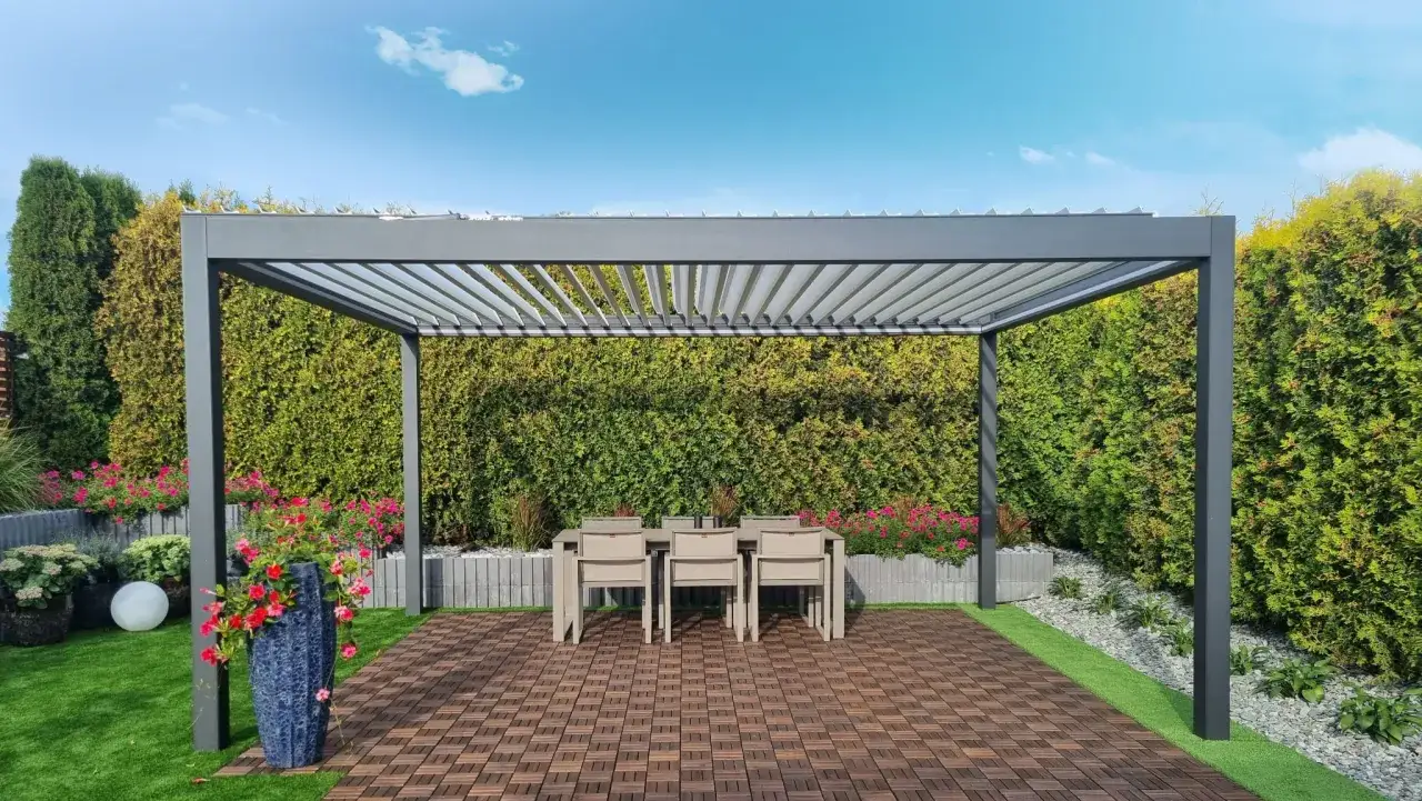 Nowoczesna pergola z regulowanym dachem, stół i krzesła. Zastanawiasz się, ile kosztuje zrobienie pergoli?