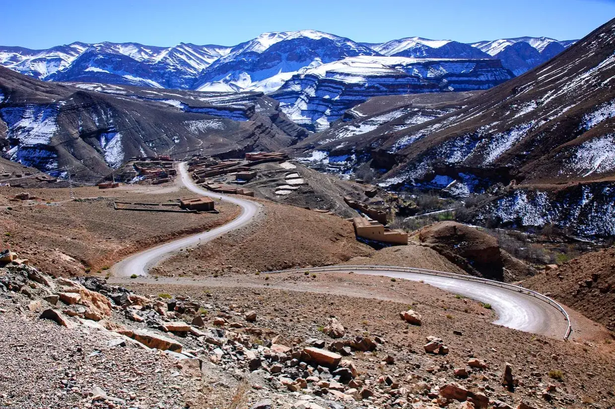 Kręta droga przez ośnieżone g&oacute;ry Wysokiego Atlasu, prowadząca do tradycyjnych wiosek. To jedno z miejsc, kt&oacute;re warto zobaczyć w Maroku.