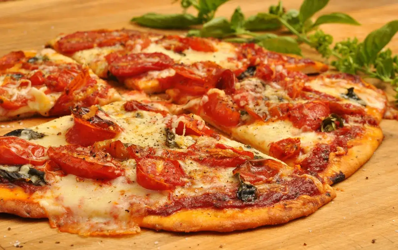 Pyszna pizza z pomidorami, serem i plasterkami peperoni, które pochodzi z pikantnych papryczek.