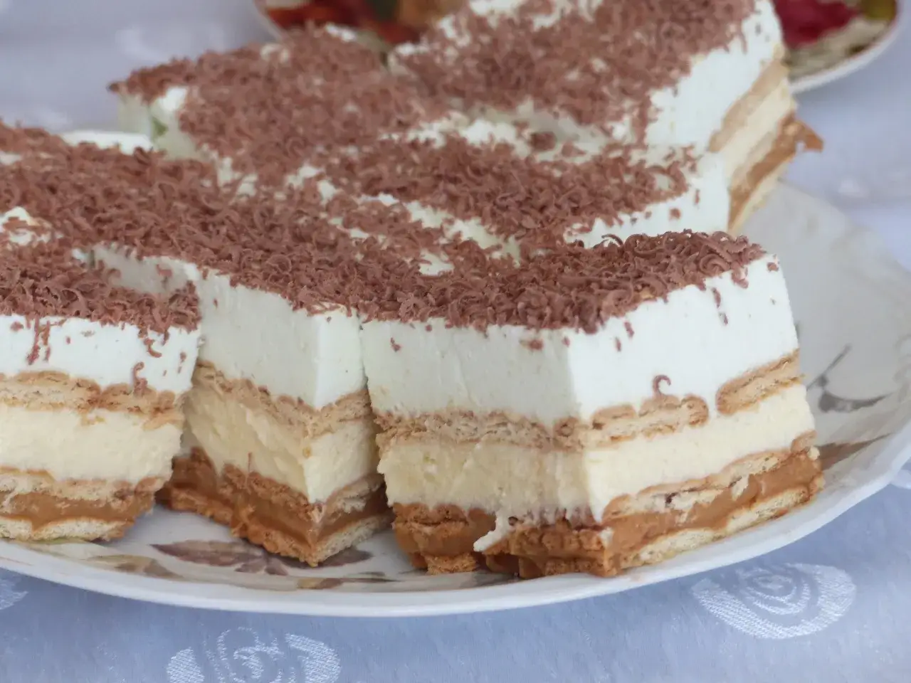 Pyszne, tanie ciasto bez pieczenia z herbatnikami, kremem i karmelem, posypane czekoladą. Idealne na deser!