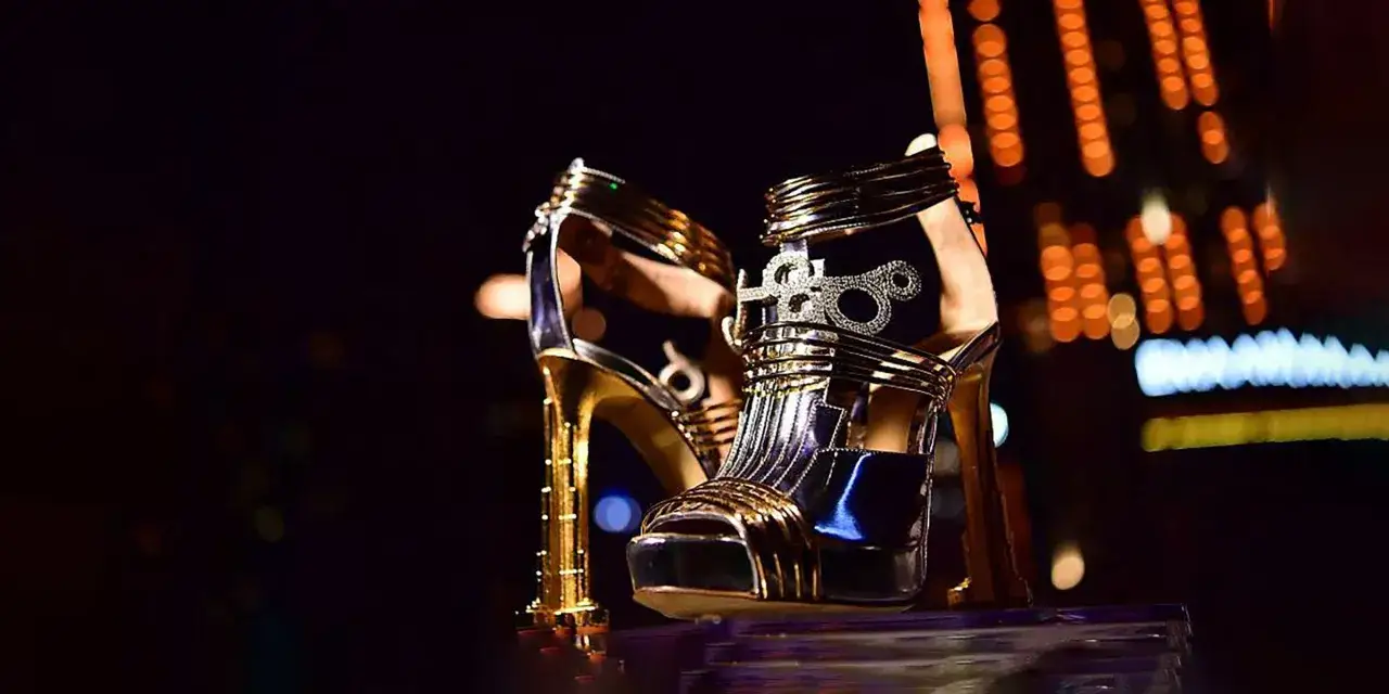 Złote sandały na obcasie, ozdobione cyrkoniami, wyglądają jak najdroższe buty na świecie. Ich blask przyciąga wzrok.