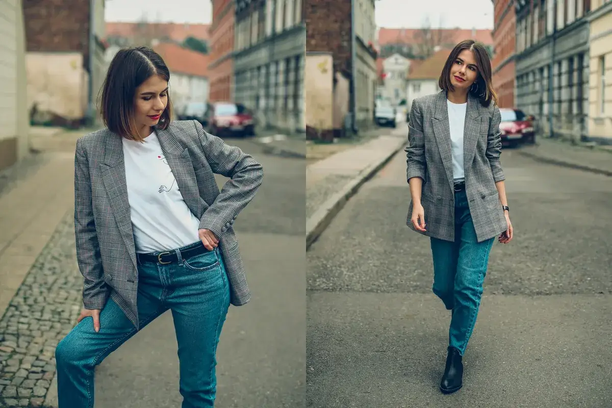 Kobieta w T-shircie pod marynarkę i jeansach na ulicy.