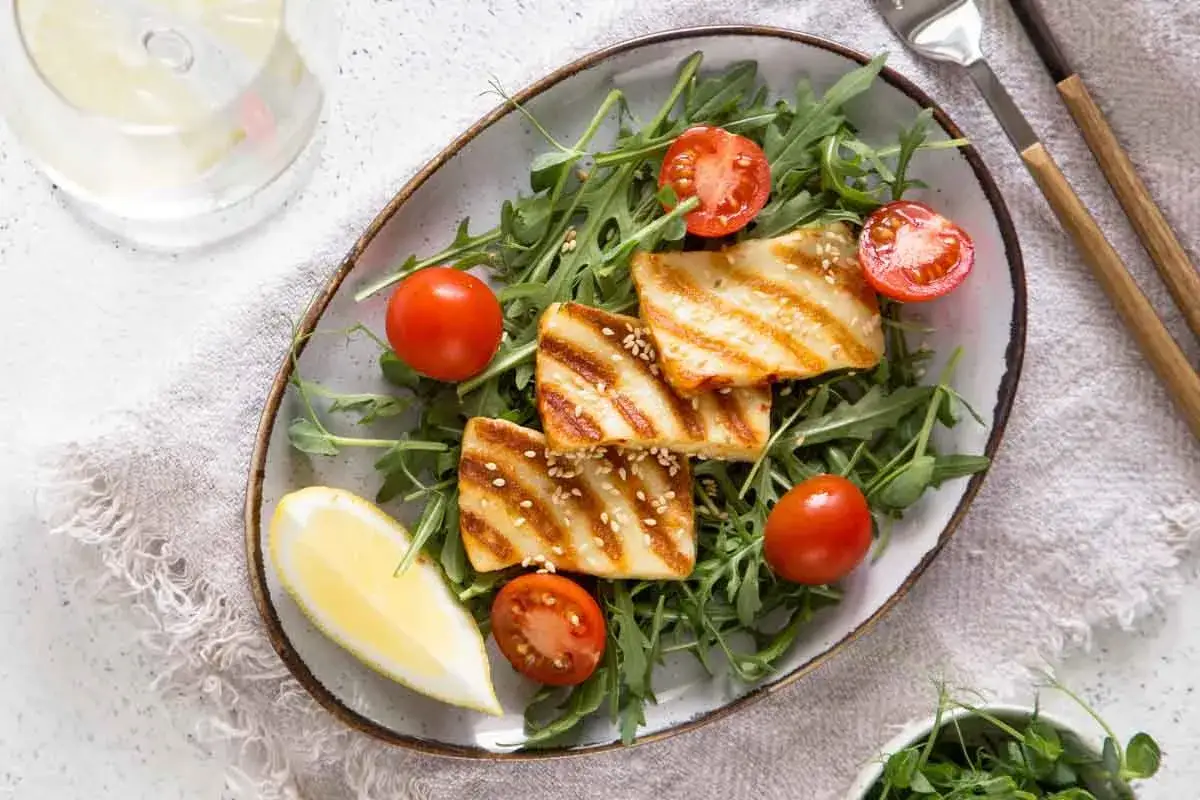 Smażony halloumi na sałatce z rukoli i pomidorkami, z cytryną. Idealny sposób, by dowiedzieć się, czy halloumi smażyć na oleju.