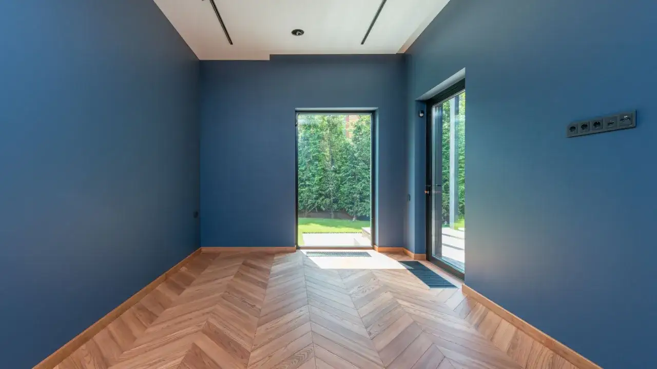Nowe, niebieskie ściany i drewniana podłoga w jodełkę. Zastanawiasz się, ile za malowanie pokoju?